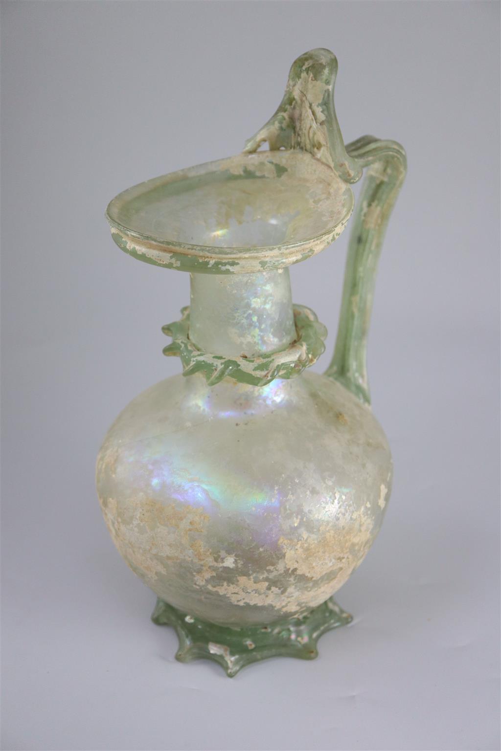 A good Roman olive green glass ewer or pitcher, Eastern Mediterranean, 3rd/4th century AD, 32cm high